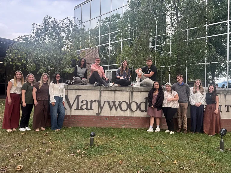 photo of students around marywood campus sign
